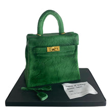 Load image into Gallery viewer, Hand-sculpted green Kelly-style handbag cake with realistic edible details by Bal Cakery, London.