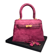 Load image into Gallery viewer, Hand-sculpted pink Kelly-style handbag cake with realistic edible details by Bal Cakery, London.