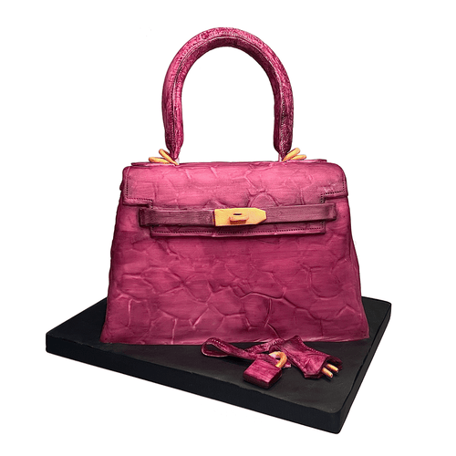 Hand-sculpted pink Kelly-style handbag cake with realistic edible details by Bal Cakery, London.