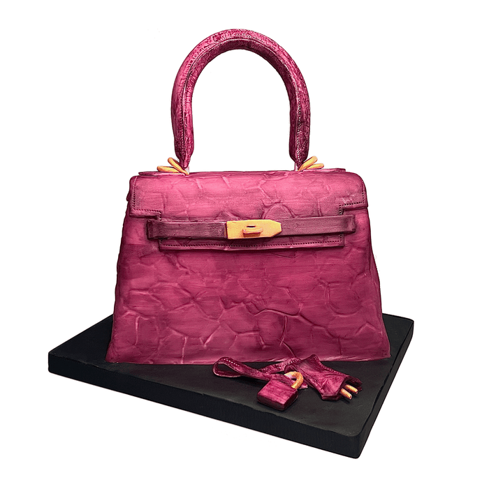 Hand-sculpted pink Kelly-style handbag cake with realistic edible details by Bal Cakery, London.